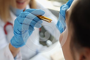 Doctor neurologist shining flashlight on patient eyes in clinic closeup