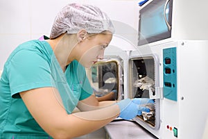 Doctor, nurce or cosmetologist sterilizes instruments in autoclave