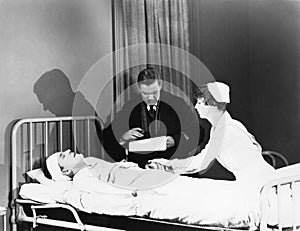 Doctor and nurse attending to a patient in a hospital bed