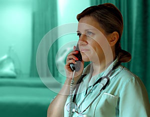 Doctor or nurse call by phone. Woman in uniform with handset and stethoscope around neck speaks consulting