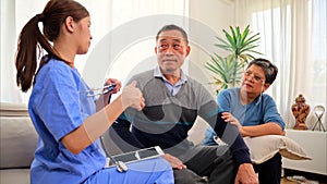 Doctor or nurse caregiver with senior patient at home or nursing home, Female doctor holding tablet visiting patient in