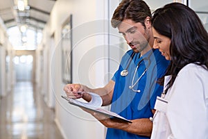 Doctor and nurse discussing medical report at clinic