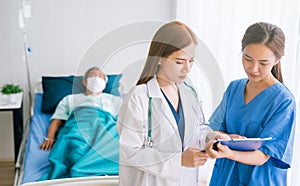 Doctor and nurse doing in a room at hospital and visiting a patient updating patient`s medical report.