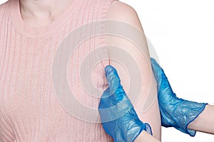 Doctor or nurse examine tuberculosis vaccine BCG marks on the shoulder of an adult woman made in childhood