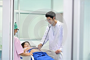 Doctor, nurse examining pregnant woman with stethoscope