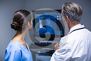 Doctor and nurse examining x-ray on computer