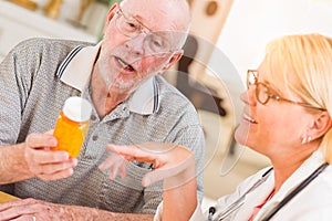 Doctor or Nurse Explaining Prescription Medicine to Attentive Senior Man