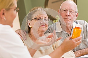 Doctor or Nurse Explaining Prescription Medicine to Senior Couple