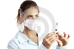 Doctor or nurse in face mask and lab coat holding syringe.