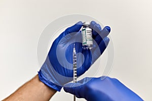 Doctor, nurse hand in blue gloves holding coronavirus covid-19 vaccine