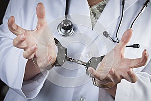 Doctor or Nurse In Handcuffs Wearing Lab Coat and Stethoscope