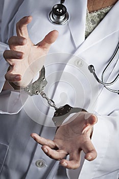 Doctor or Nurse In Handcuffs Wearing Lab Coat and Stethoscope