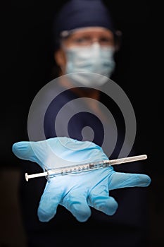 Doctor or Nurse Holding Medical Syringe with Needle