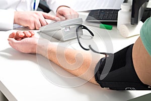 Doctor or nurse measure blood pressure of a patient.