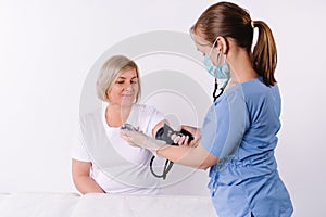 A doctor nurse measures blood pressure with a medical digital blood pressure monitor. Elderly people cardiology health