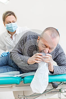 Doctor or nurse is observing a male patient while he is vomitting, corona virus concept or covid-19, sars-cov-2