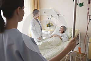 Doctor And Nurse With Patient In Hospital Room