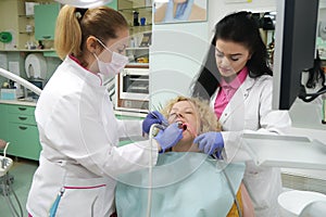 Doctor and nurse prepare female patient for dental procedure