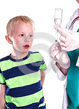 Doctor or nurse preparing injection of little boy.