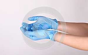 Doctor or nurse putting on blue nitrile surgical gloves, professional medical safety and hygiene