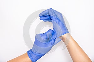 Doctor or nurse putting on blue nitrile surgical gloves, professional medical safety and hygiene for surgery and medical exam on photo