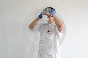 Doctor / nurse putting on a face shield to protect against the coronavirus.