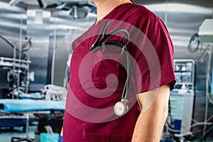 doctor or nurse in red uniform with stethoscope staning at emergency room