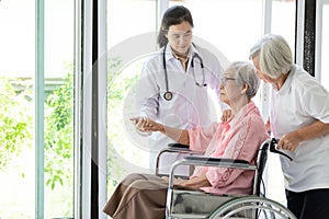 Doctor or nurse supporting disabled,alzheimer senior asian woman on wheelchair,female caregiver,elderly patient with depressive