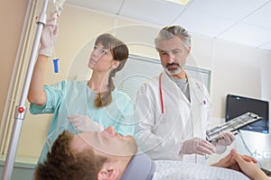 Doctor and nurse talking to patient on bed