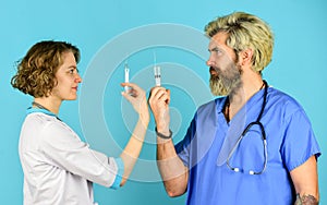 Doctor and nurse use syringe. Successful team of medical doctors. People in uniforms blue background. Medical staff