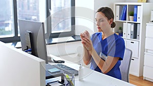 Doctor or nurse using hand sanitizer at hospital