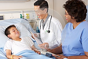 Doctor And Nurse Visiting Child Patient On Ward