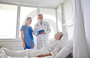 Doctor and nurse visiting senior woman at hospital