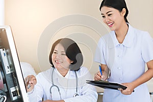 Doctor and nurse working on computer in medical office