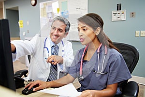 Doctor With Nurse Working At Nurses Station