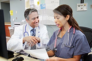 Doctor With Nurse Working At Nurses Station