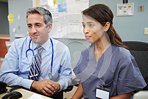 Doctor With Nurse Working At Nurses Station