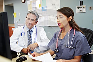 Doctor With Nurse Working At Nurses Station