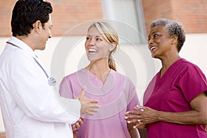 Doctor And Nurses Standing Outside A Hospital