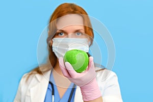 Doctor nutritionist hand with fruit on blue backgroun