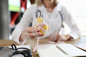 Doctor nutritionist holding ripe yellow pear with measuring tape