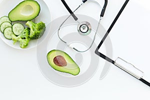 Doctor nutritionist table. Healthy and healthy food, broccoli, pickers and avacado. Stethoscope and diet pills. Top View
