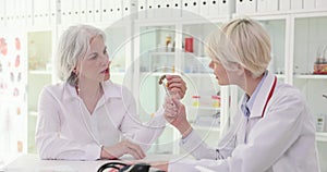 The doctor offers an elderly woman an inserted jaw