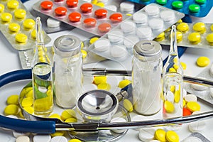 Doctor office desk with blisters of pills and clinical thermometer with stethoscope