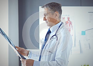 Doctor in the office examines the patient`s x-ray