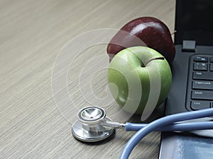 Doctor online concept, red and green apple with stethoscope on computer laptop for consultation with patient, medical