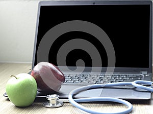 Doctor online concept, red and green apple with stethoscope on computer laptop for consultation with patient, medical