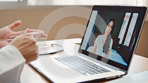 Doctor online video call explain treatment, symptom check with Asian patient woman connecting from home, using laptop computer