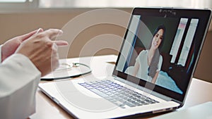 Doctor online video call explain treatment, symptom check with Asian patient woman connecting from home, using laptop computer