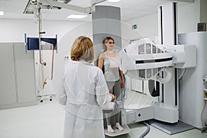 Doctor operating dynamic X-ray scan using tilting fluoroscopy unit